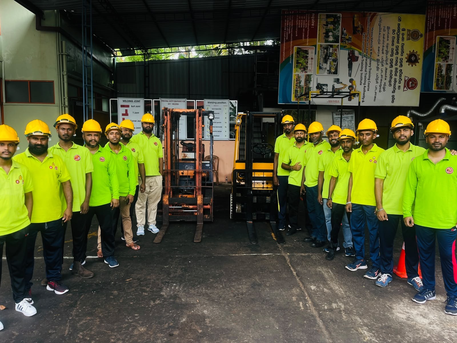 RCVTI trainees in safety gear in front of heavy machinery